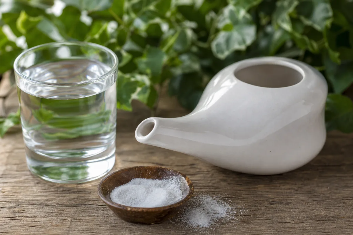 Close-up of neti pot and saline nasal rinse